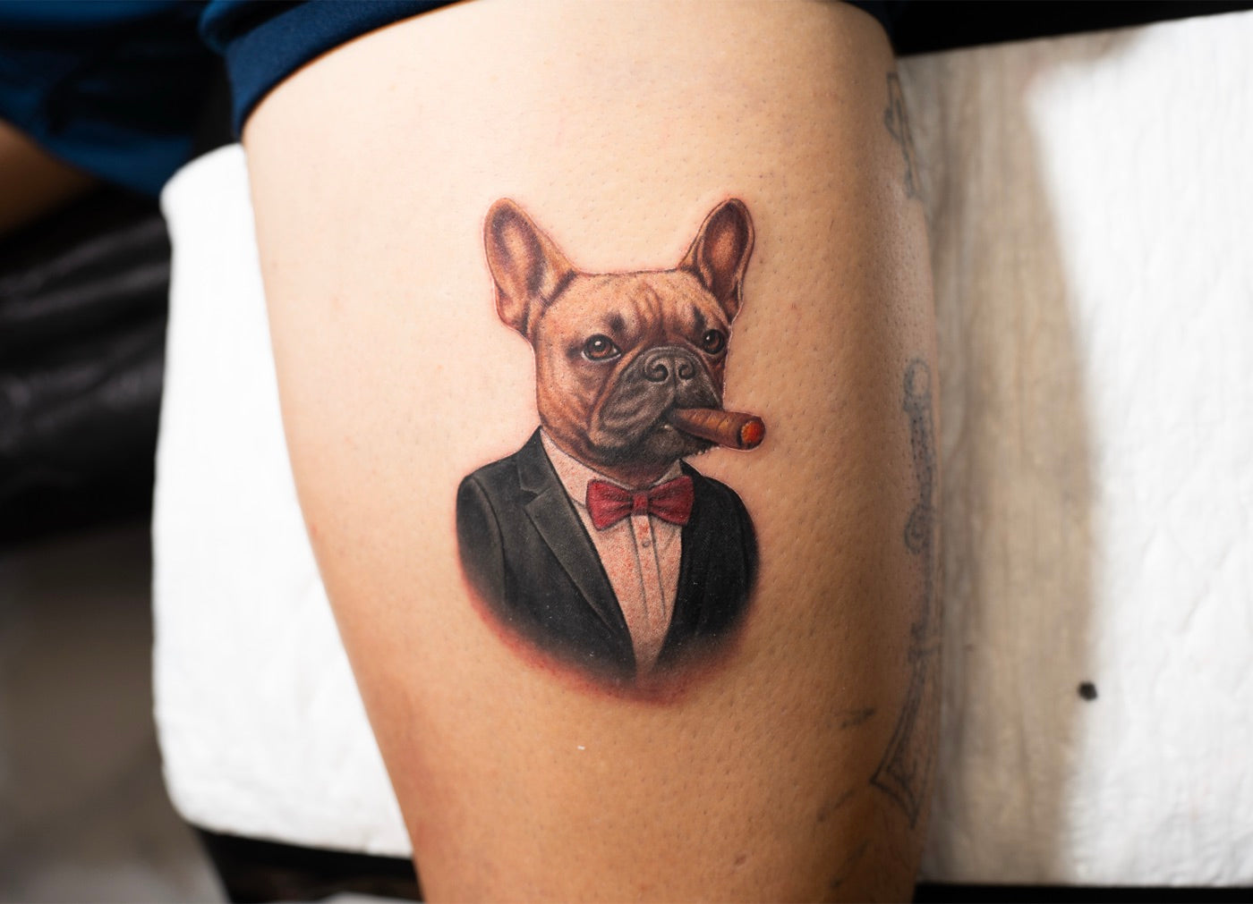 Tatuaje microrealista a color de un bulldog francés con traje y puro